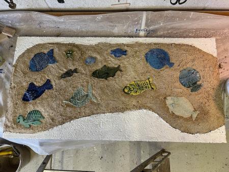 ceramic fish embedded in lime render band for Looe mural
