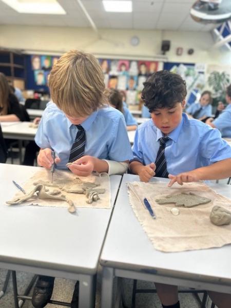 schoolchildren making clay fish at Looe Community Academy